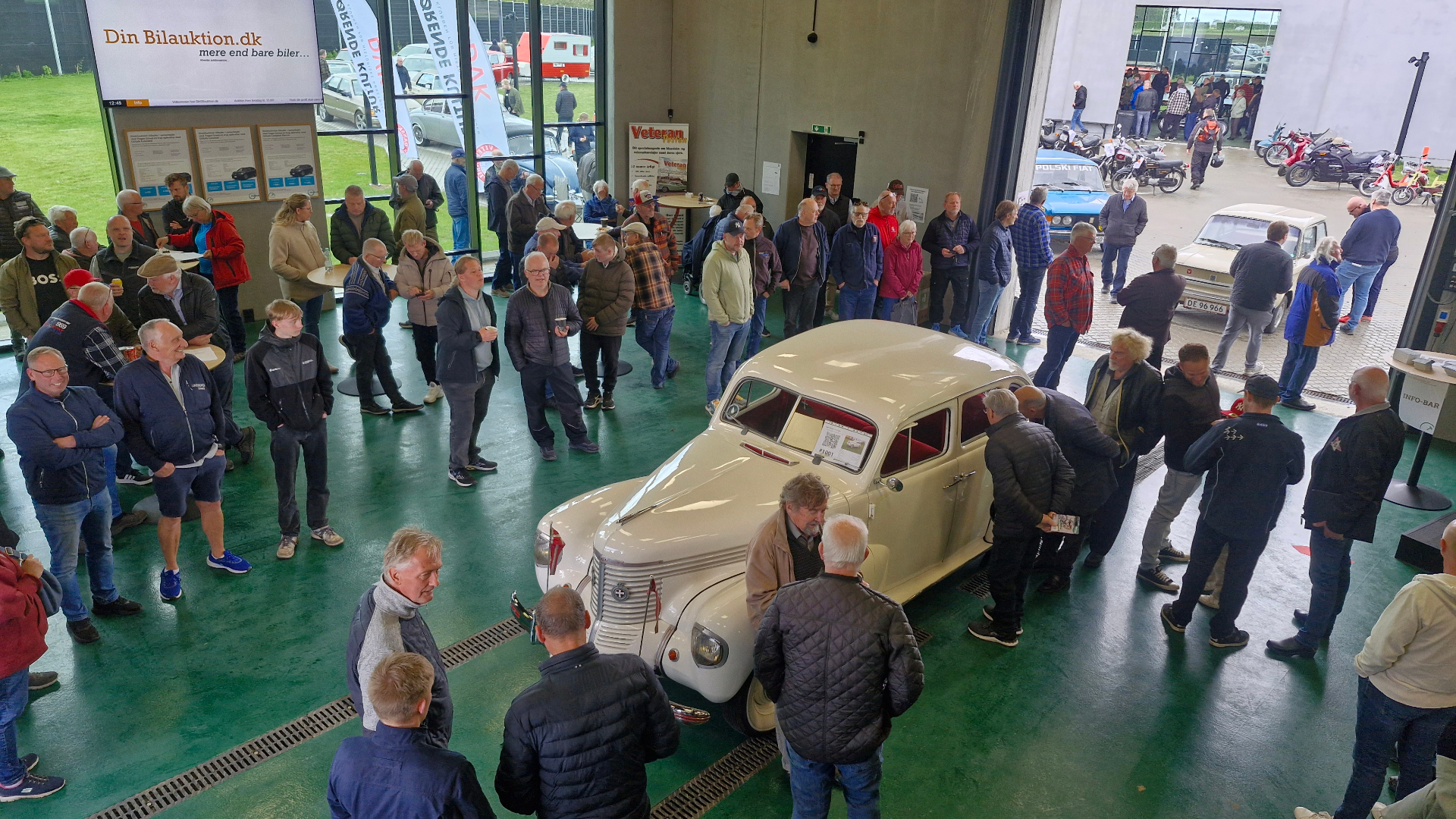 Publikum omkring en klassisk bil under auktion i DinBilauktion.dk's hal i Børkop Publikum omkring en klassisk bil under auktion i DinBilauktion.dk's hal i Børkop
